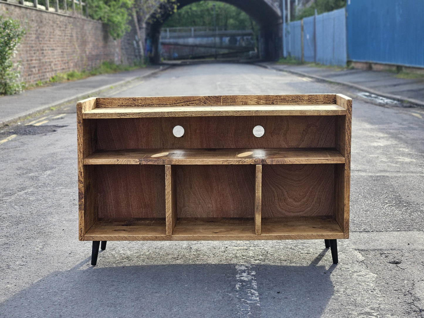 Rustic vinyl record storage unit with space to store vinyl records, space for an amplifier and space for a turntable. Unit has mid century legs