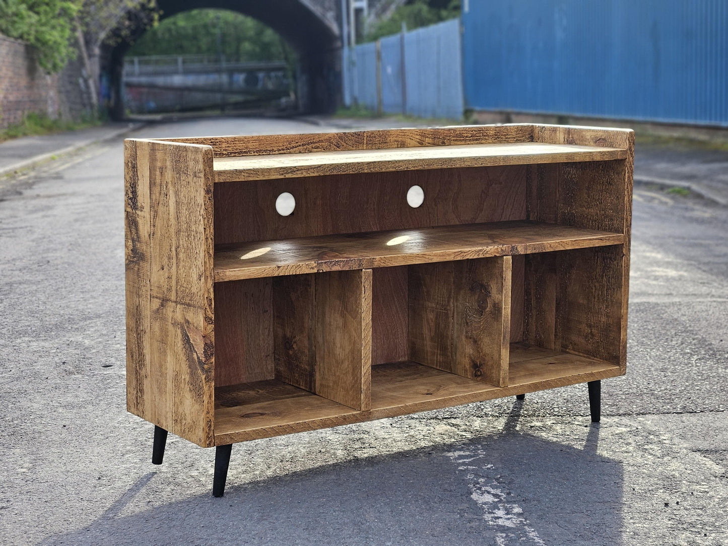 Rustic vinyl record storage unit with space to store vinyl records, space for an amplifier and space for a turntable. Unit has mid century legs